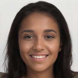 Joyful black young-adult female with long  brown hair and brown eyes