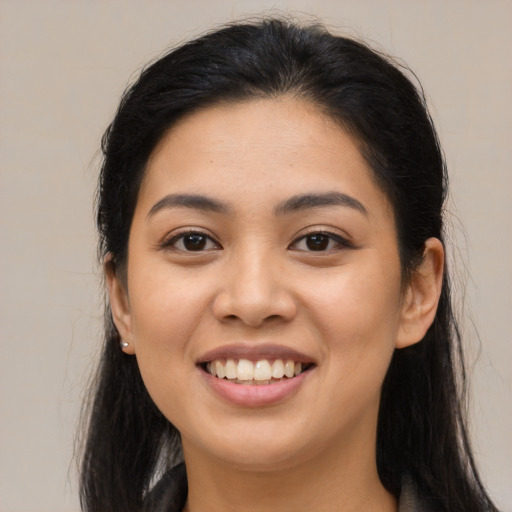 Joyful latino young-adult female with long  brown hair and brown eyes