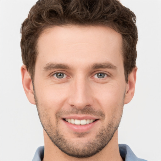 Joyful white young-adult male with short  brown hair and grey eyes