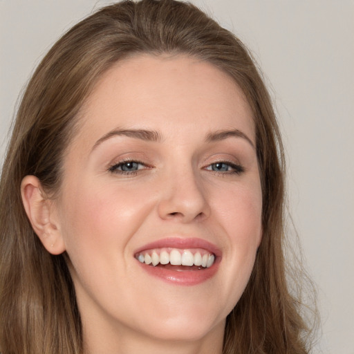 Joyful white young-adult female with long  brown hair and grey eyes