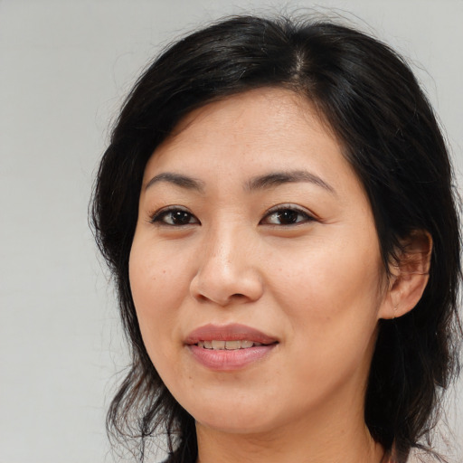 Joyful asian young-adult female with long  brown hair and brown eyes