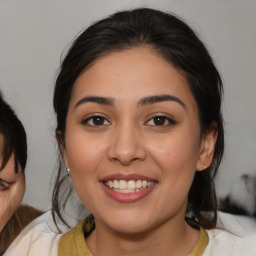 Joyful latino young-adult female with medium  brown hair and brown eyes