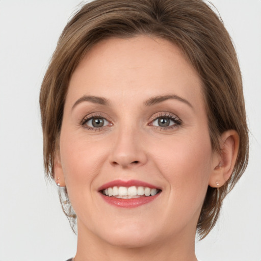 Joyful white young-adult female with medium  brown hair and green eyes