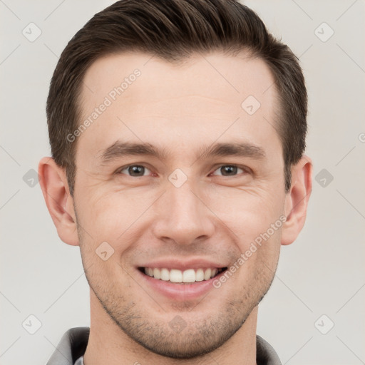 Joyful white young-adult male with short  brown hair and grey eyes