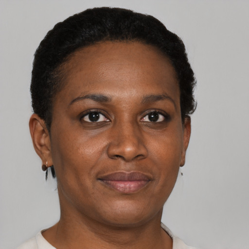 Joyful black adult female with short  brown hair and brown eyes