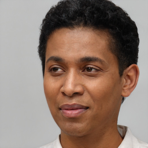 Joyful latino adult male with short  brown hair and brown eyes