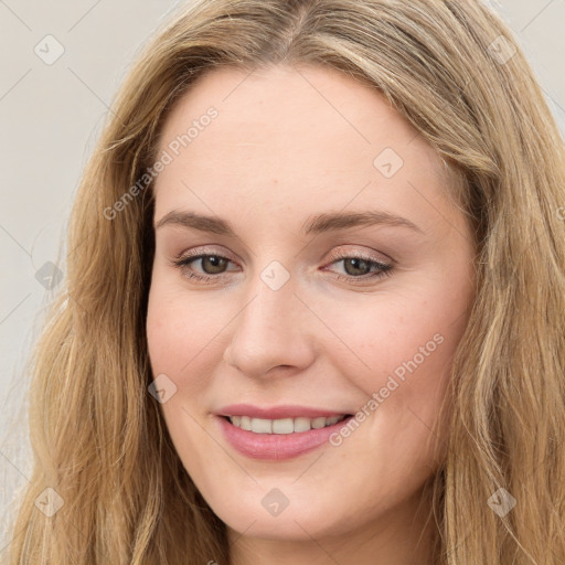 Joyful white young-adult female with long  brown hair and green eyes