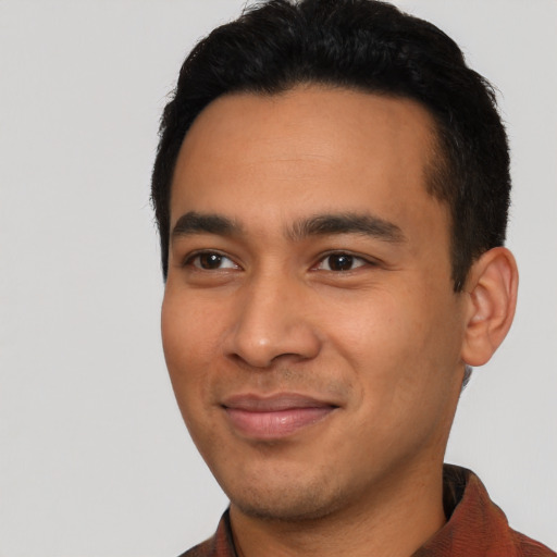 Joyful latino young-adult male with short  black hair and brown eyes