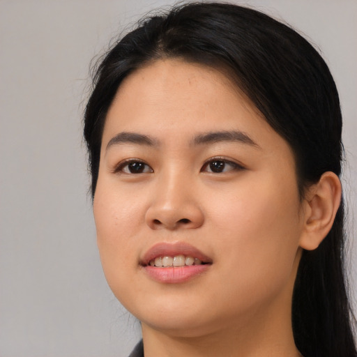 Joyful asian young-adult female with long  black hair and brown eyes
