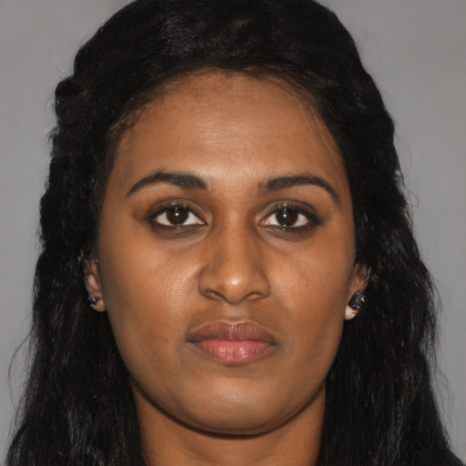 Joyful black young-adult female with long  black hair and brown eyes