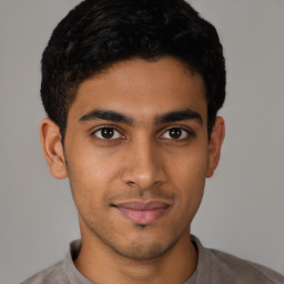 Joyful latino young-adult male with short  brown hair and brown eyes