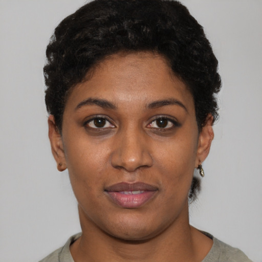 Joyful black young-adult female with short  black hair and brown eyes