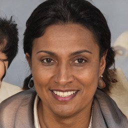 Joyful latino adult female with medium  brown hair and brown eyes