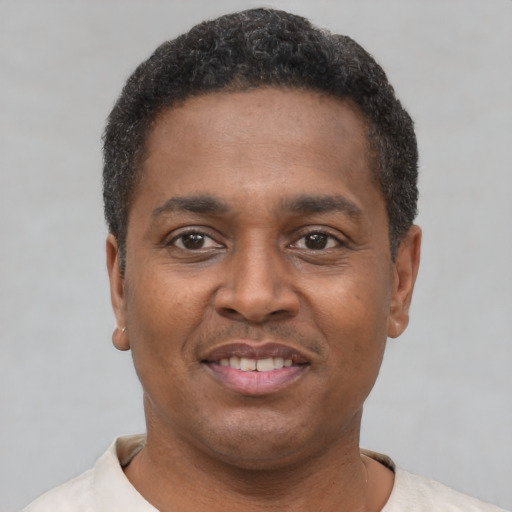 Joyful latino young-adult male with short  brown hair and brown eyes