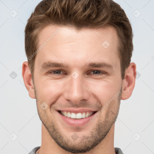 Joyful white young-adult male with short  brown hair and grey eyes