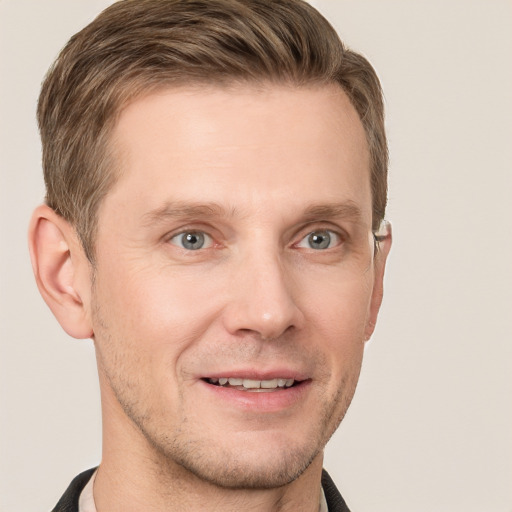 Joyful white young-adult male with short  brown hair and grey eyes