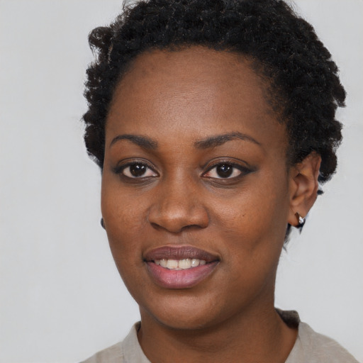 Joyful black young-adult female with short  black hair and brown eyes