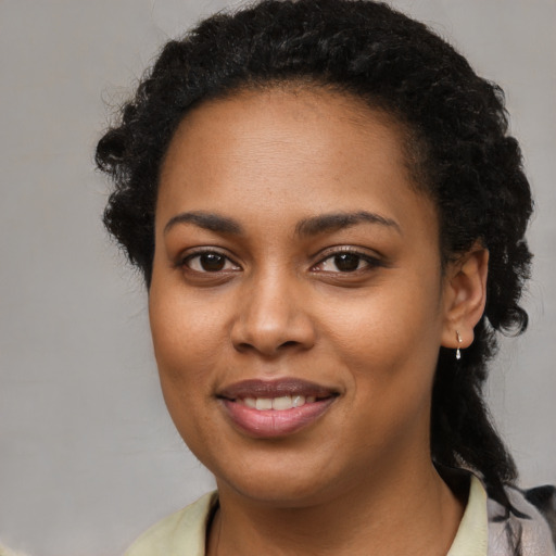 Joyful black young-adult female with medium  black hair and brown eyes