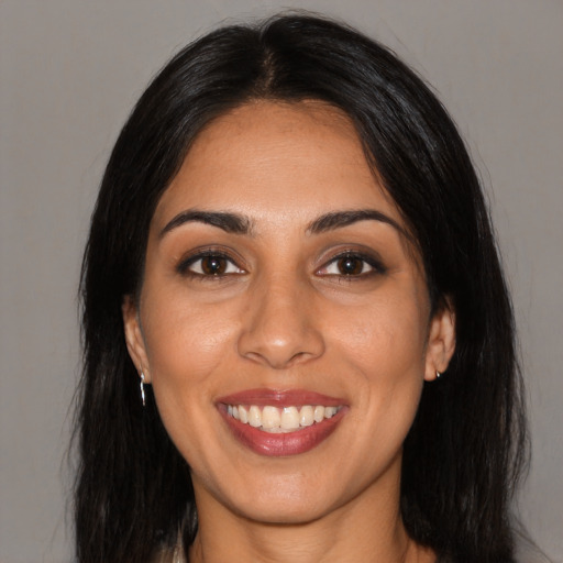 Joyful latino young-adult female with long  black hair and brown eyes