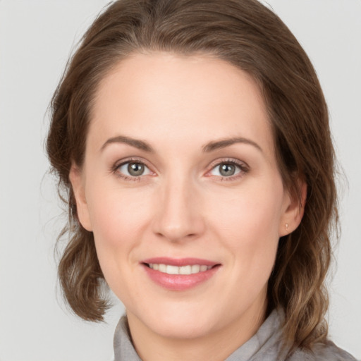 Joyful white young-adult female with medium  brown hair and grey eyes