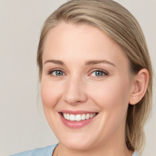 Joyful white young-adult female with long  brown hair and blue eyes