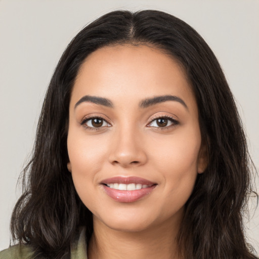 Joyful latino young-adult female with long  brown hair and brown eyes