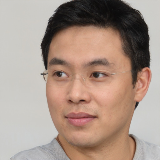 Joyful asian young-adult male with short  black hair and brown eyes