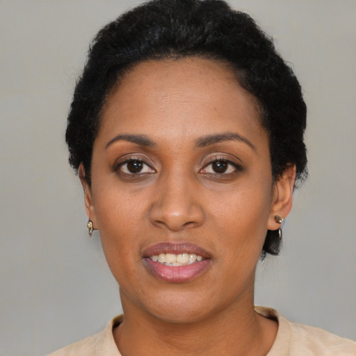 Joyful black adult female with short  black hair and brown eyes