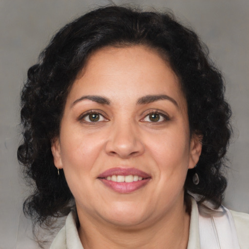 Joyful latino adult female with medium  brown hair and brown eyes