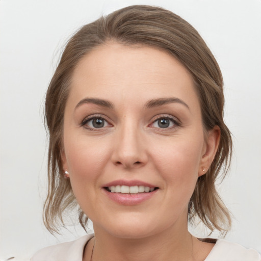 Joyful white young-adult female with medium  brown hair and grey eyes