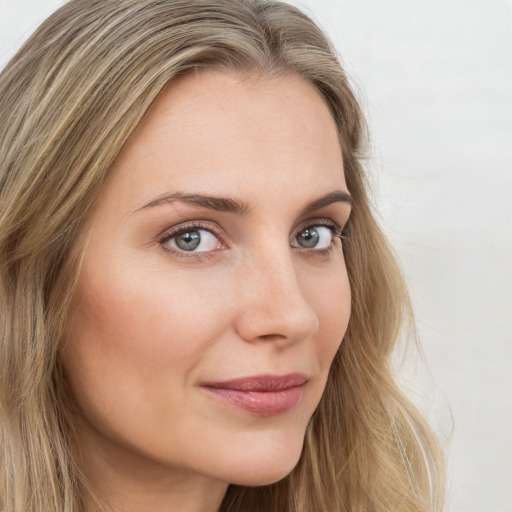 Joyful white young-adult female with long  brown hair and green eyes