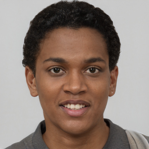 Joyful black young-adult female with short  black hair and brown eyes
