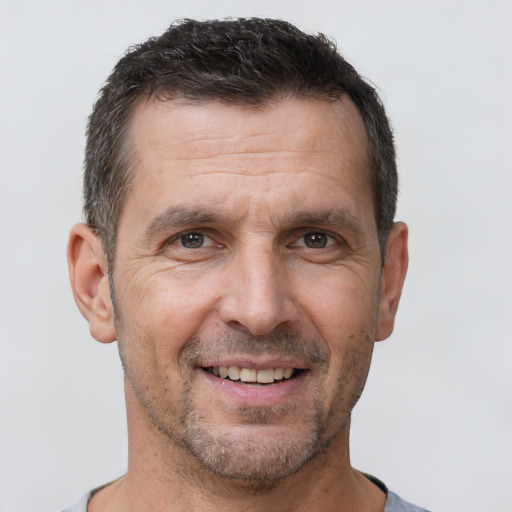 Joyful white adult male with short  brown hair and brown eyes