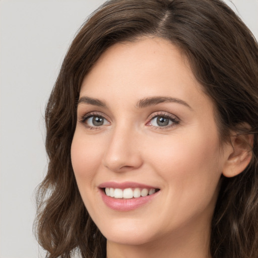 Joyful white young-adult female with long  brown hair and green eyes