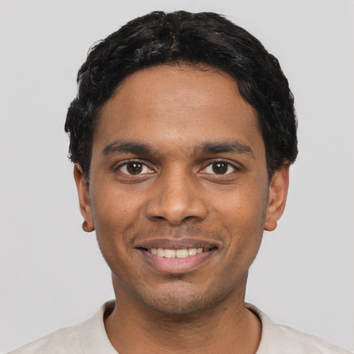Joyful black young-adult male with short  black hair and brown eyes