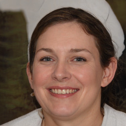 Joyful white adult female with medium  brown hair and blue eyes