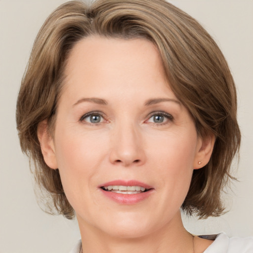 Joyful white adult female with medium  brown hair and grey eyes