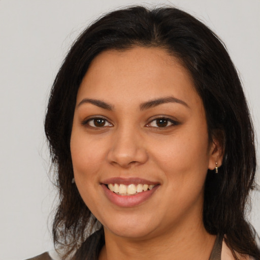 Joyful latino young-adult female with medium  brown hair and brown eyes