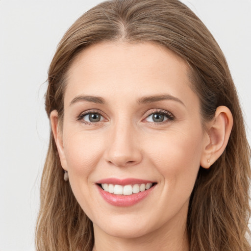 Joyful white young-adult female with long  brown hair and grey eyes