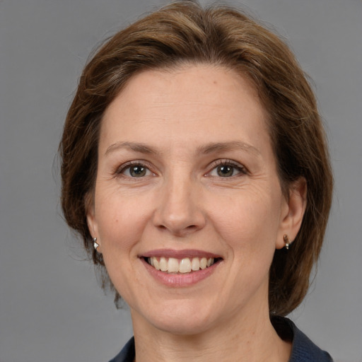 Joyful white adult female with medium  brown hair and grey eyes