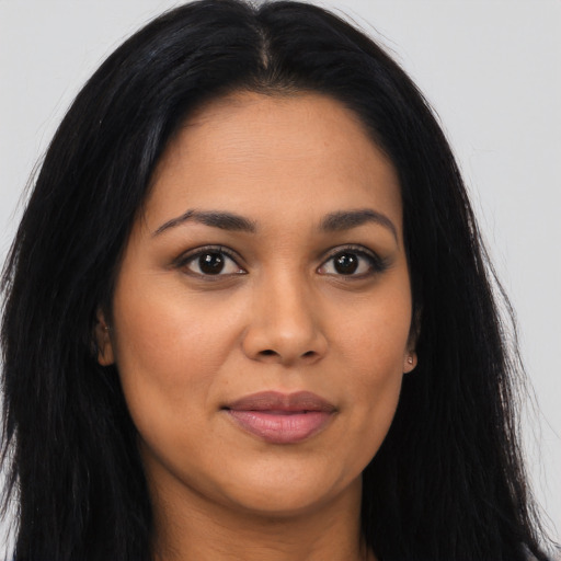 Joyful latino young-adult female with long  brown hair and brown eyes