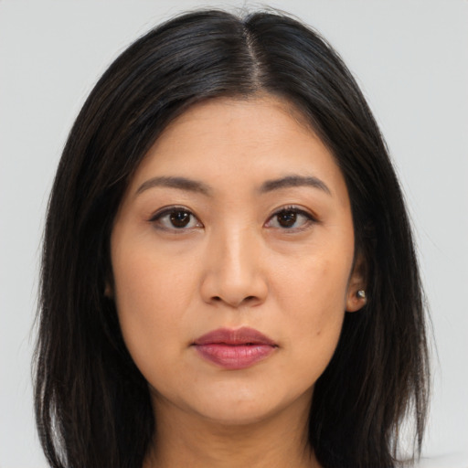 Joyful asian young-adult female with long  brown hair and brown eyes