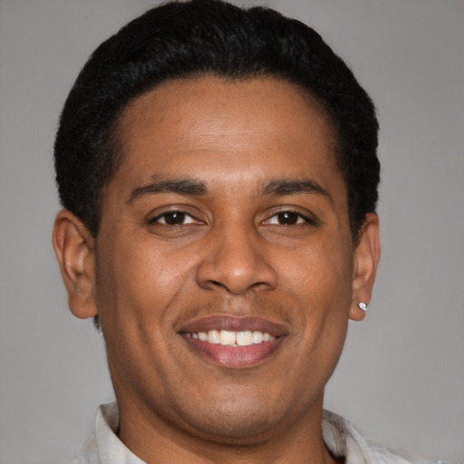 Joyful latino young-adult male with short  brown hair and brown eyes