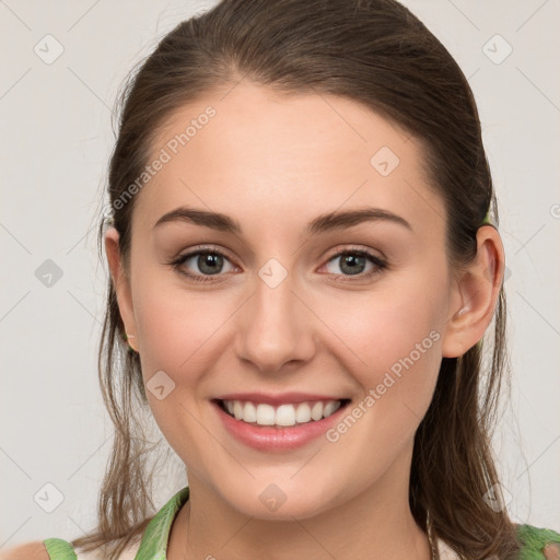 Joyful white young-adult female with medium  brown hair and green eyes