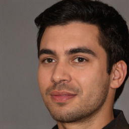 Joyful white young-adult male with short  black hair and brown eyes