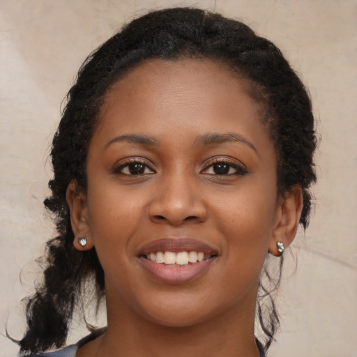 Joyful black young-adult female with long  brown hair and brown eyes