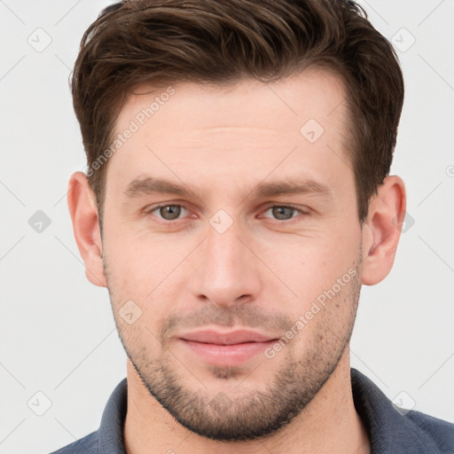 Joyful white young-adult male with short  brown hair and grey eyes