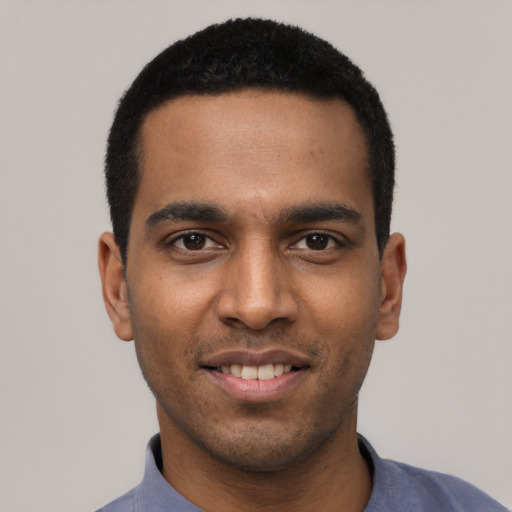 Joyful black young-adult male with short  black hair and brown eyes