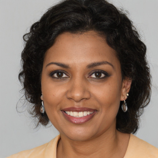 Joyful black young-adult female with medium  brown hair and brown eyes