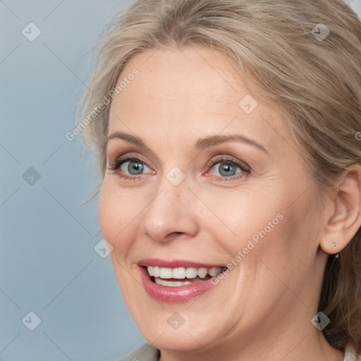 Joyful white adult female with medium  brown hair and blue eyes